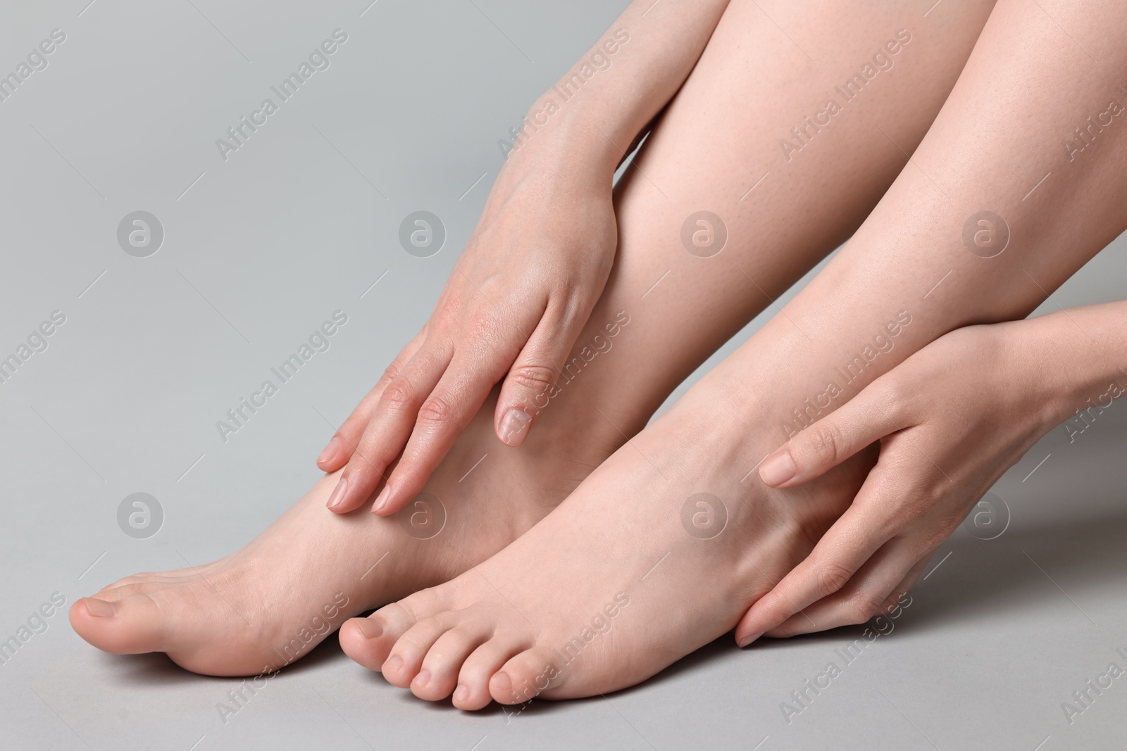 Photo of Closeup view of woman`s groomed feet after care procedure on grey background