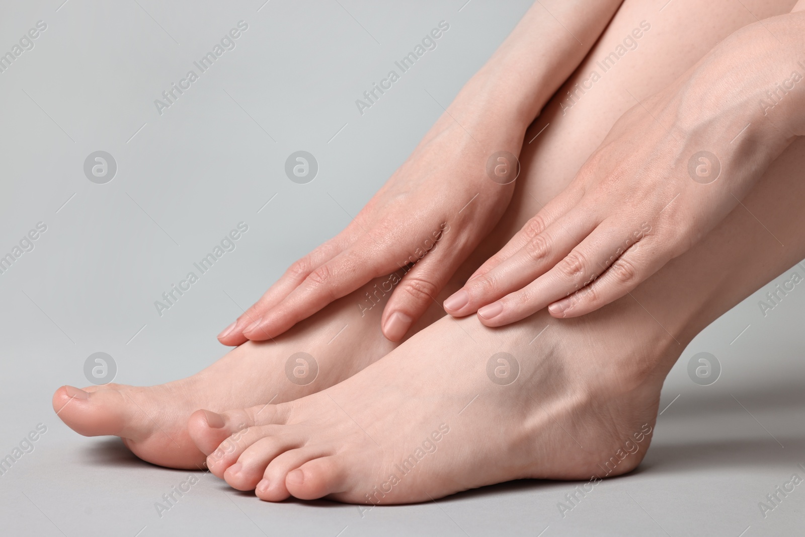 Photo of Closeup view of woman`s groomed feet after care procedure on grey background