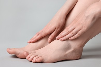 Closeup view of woman`s groomed feet after care procedure on grey background