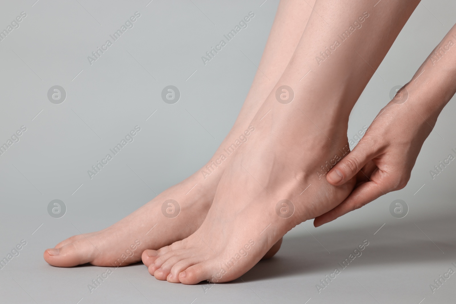 Photo of Closeup view of woman`s groomed feet after care procedure on grey background