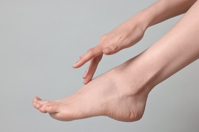 Photo of Closeup view of woman`s groomed foot after care procedure on grey background