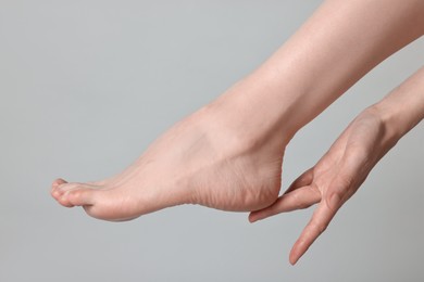 Photo of Closeup view of woman`s groomed foot after care procedure on grey background