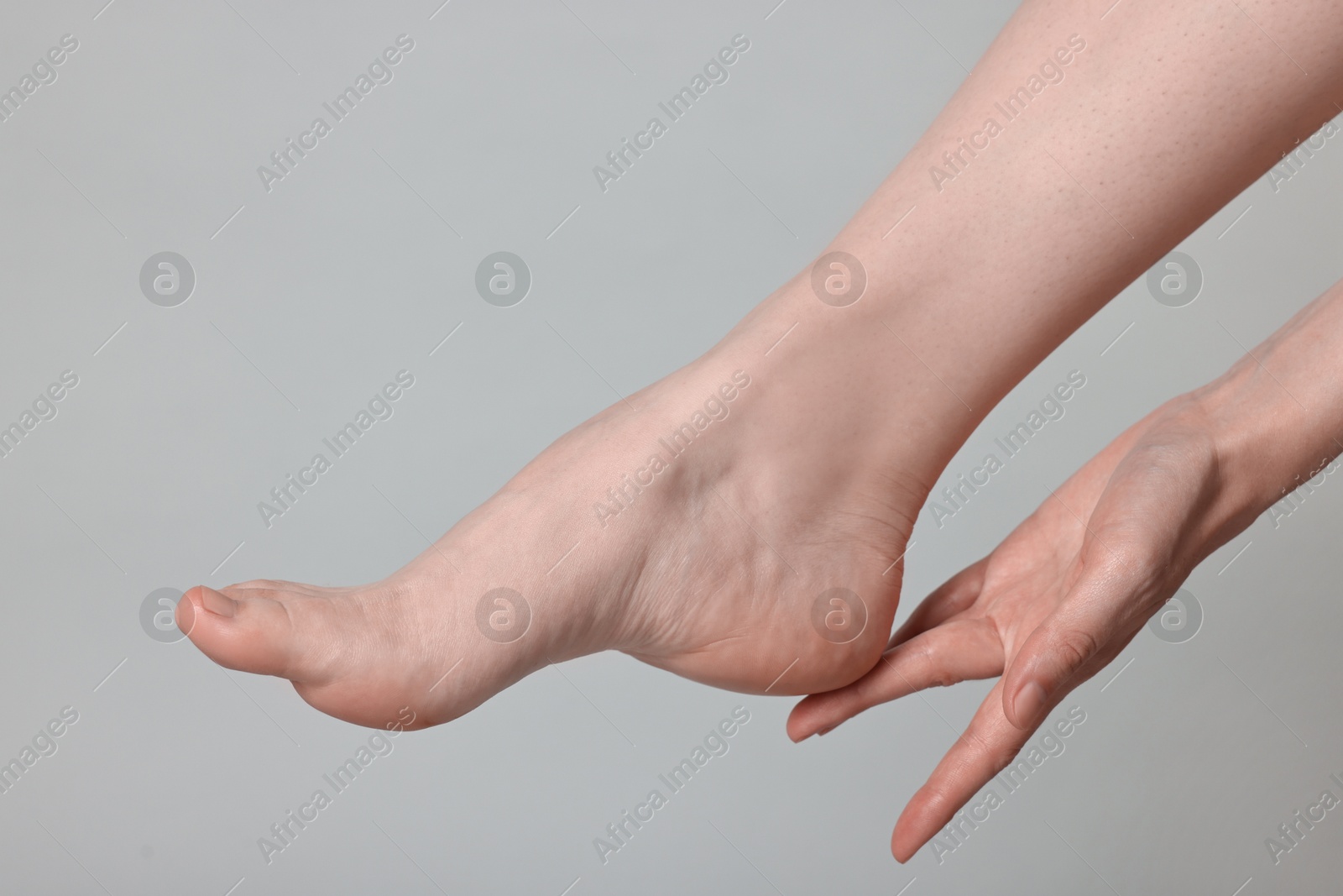 Photo of Closeup view of woman`s groomed foot after care procedure on grey background