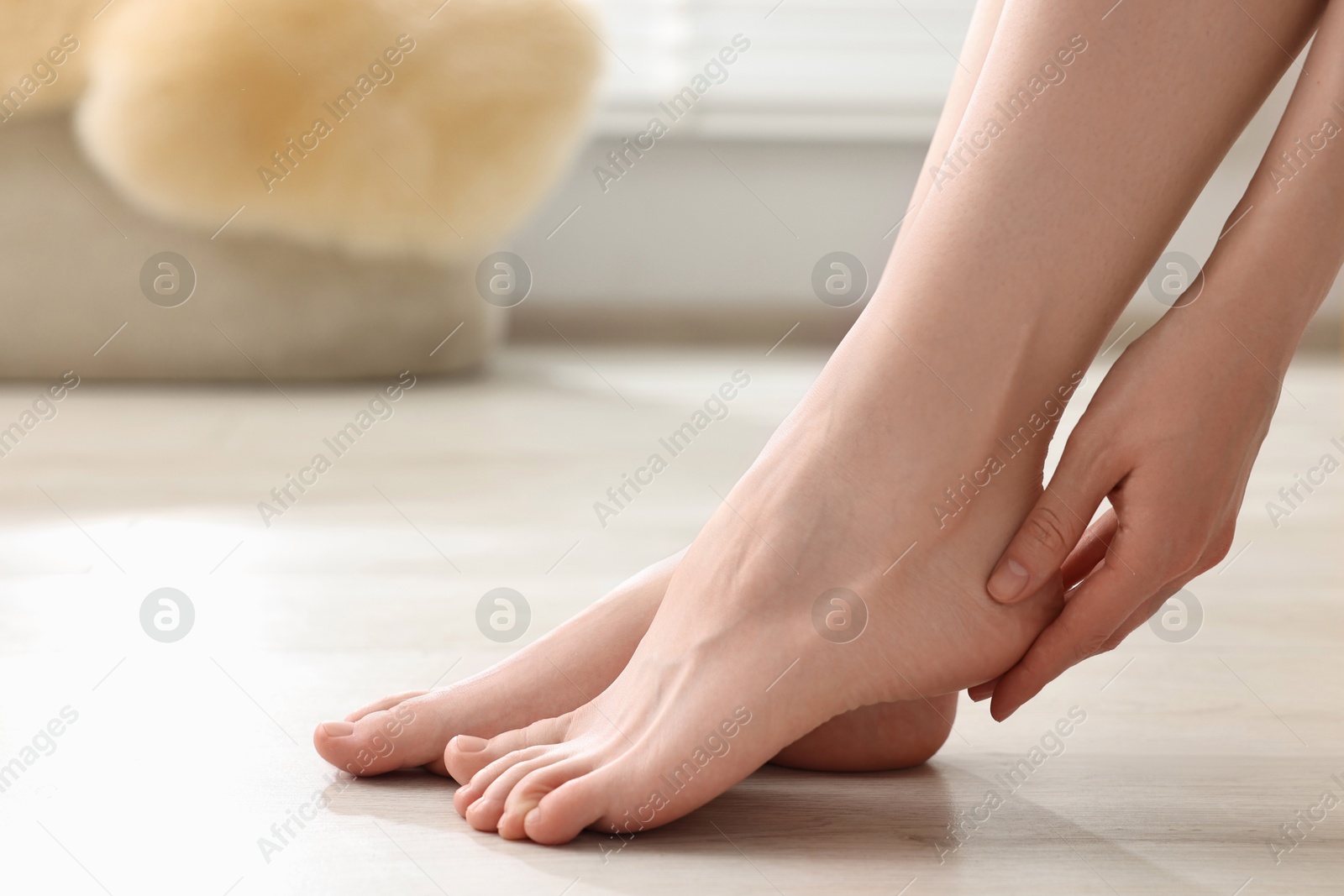 Photo of Closeup view of woman`s groomed feet after care procedure on floor