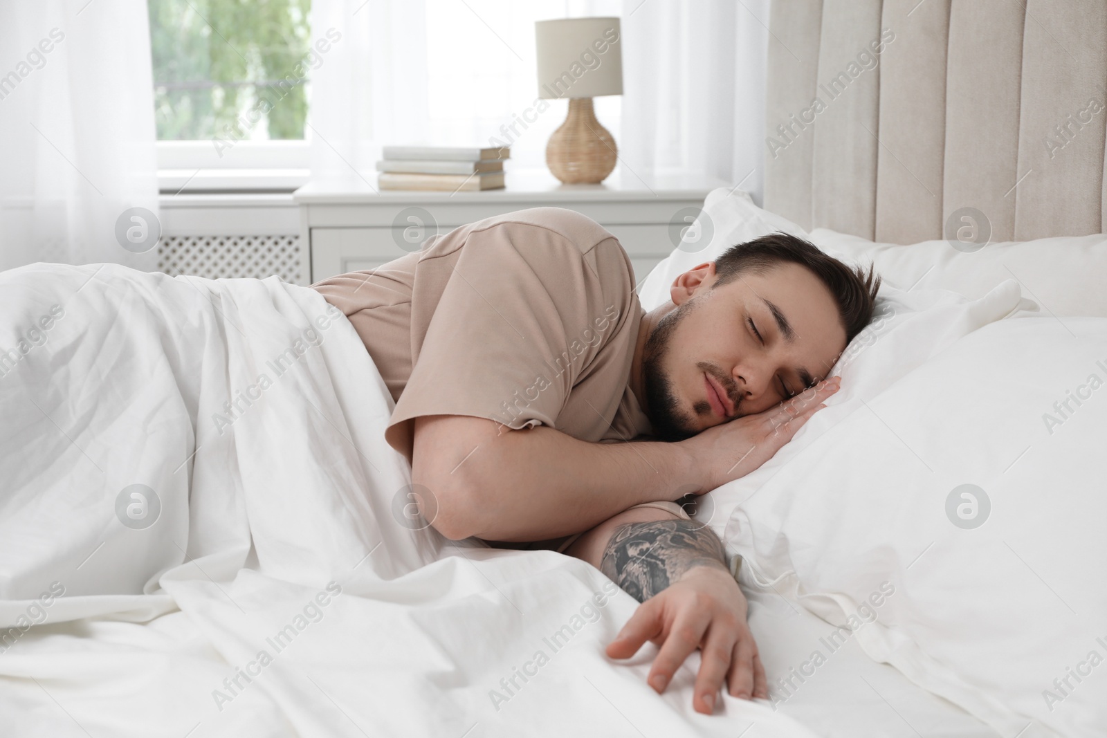 Photo of Bedtime. Handsome man sleeping in bed at home