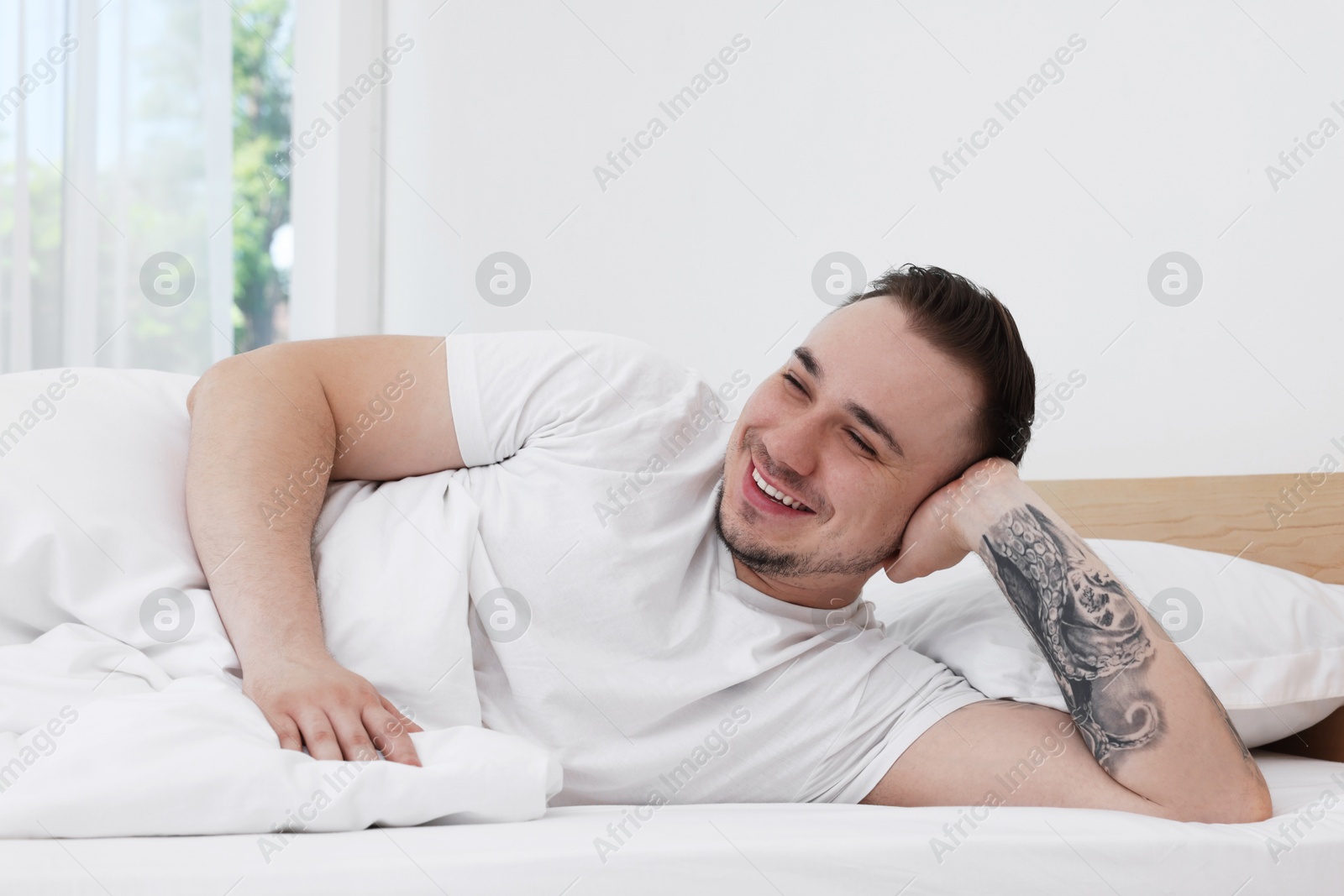 Photo of Bedtime. Handsome man lying in bed indoors