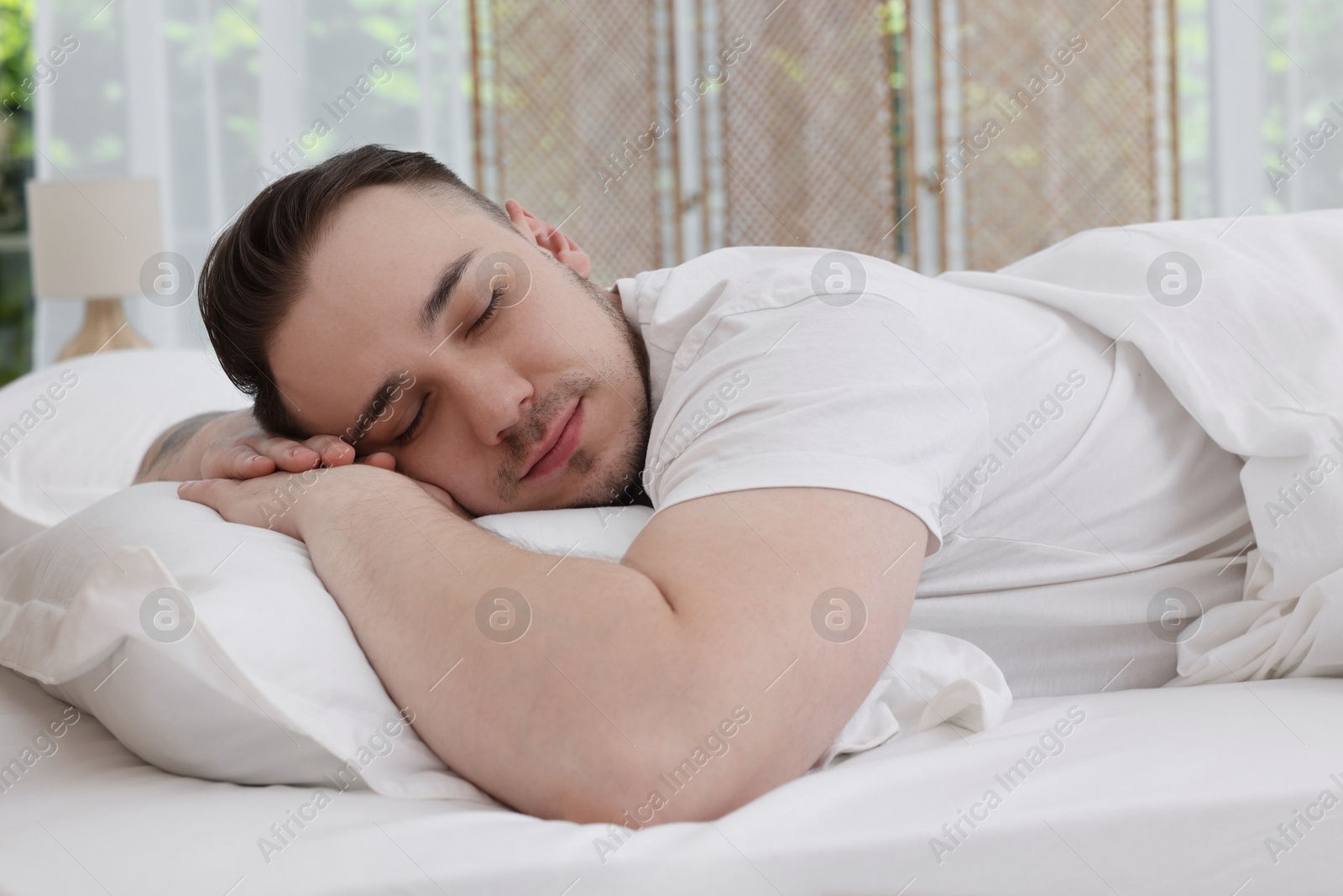 Photo of Bedtime. Handsome man sleeping in bed indoors