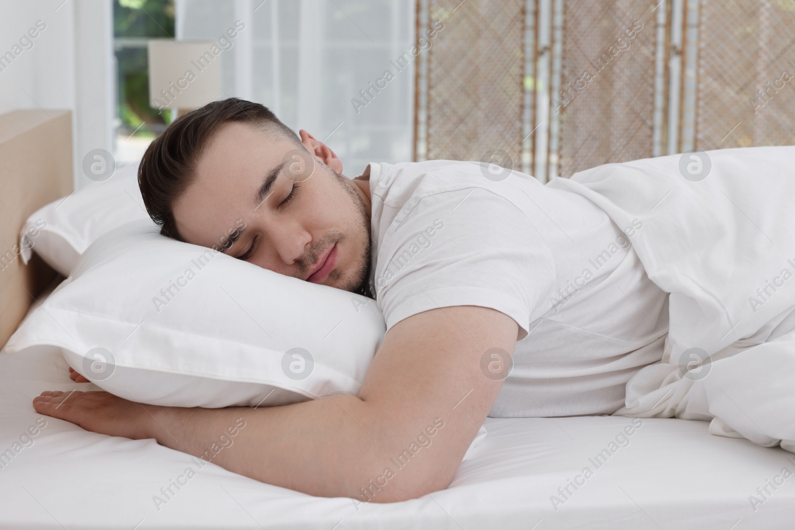 Photo of Bedtime. Handsome man sleeping in bed indoors