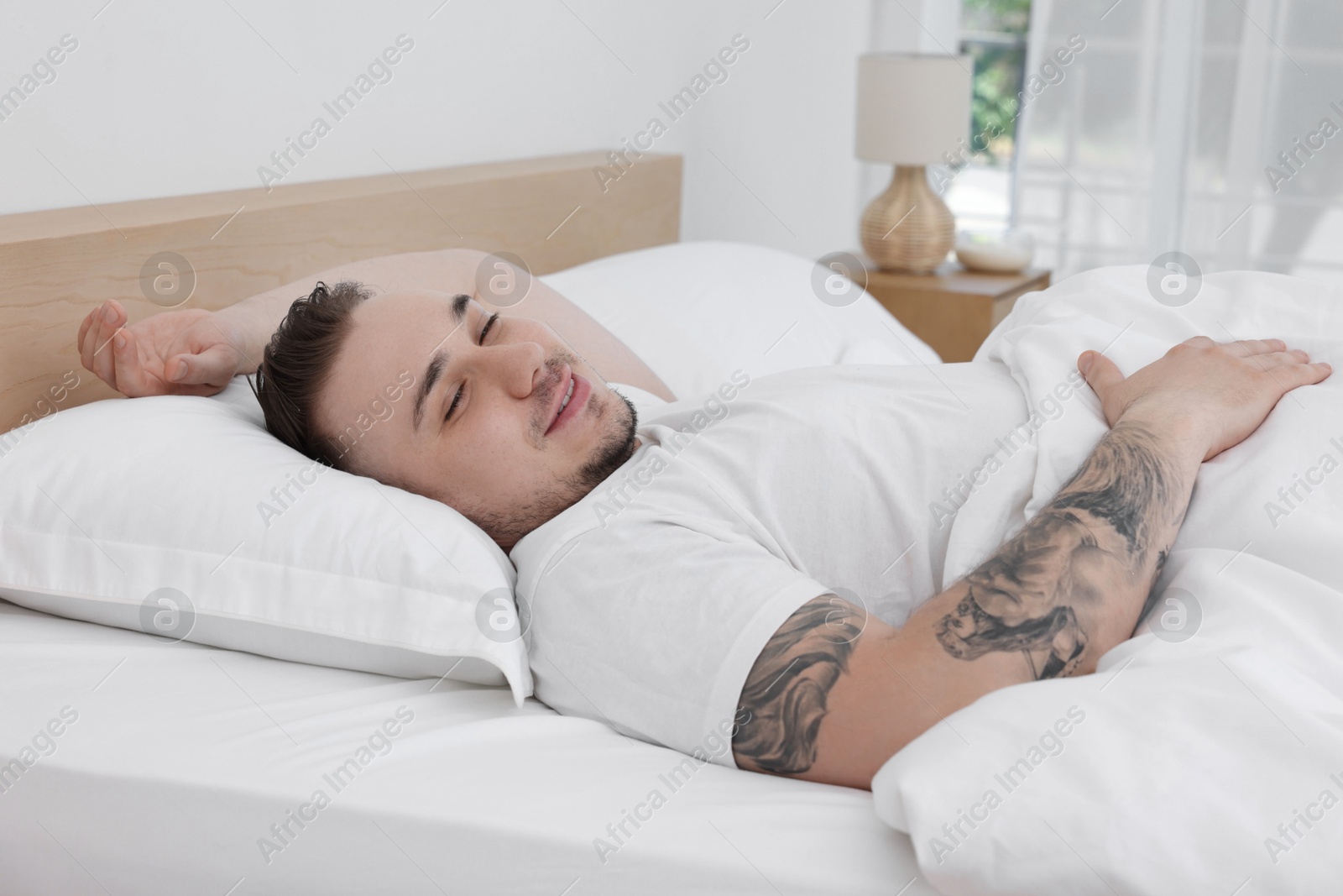 Photo of Bedtime. Handsome man sleeping in bed indoors