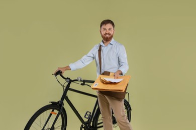 Postman with bicycle delivering letters on light green background