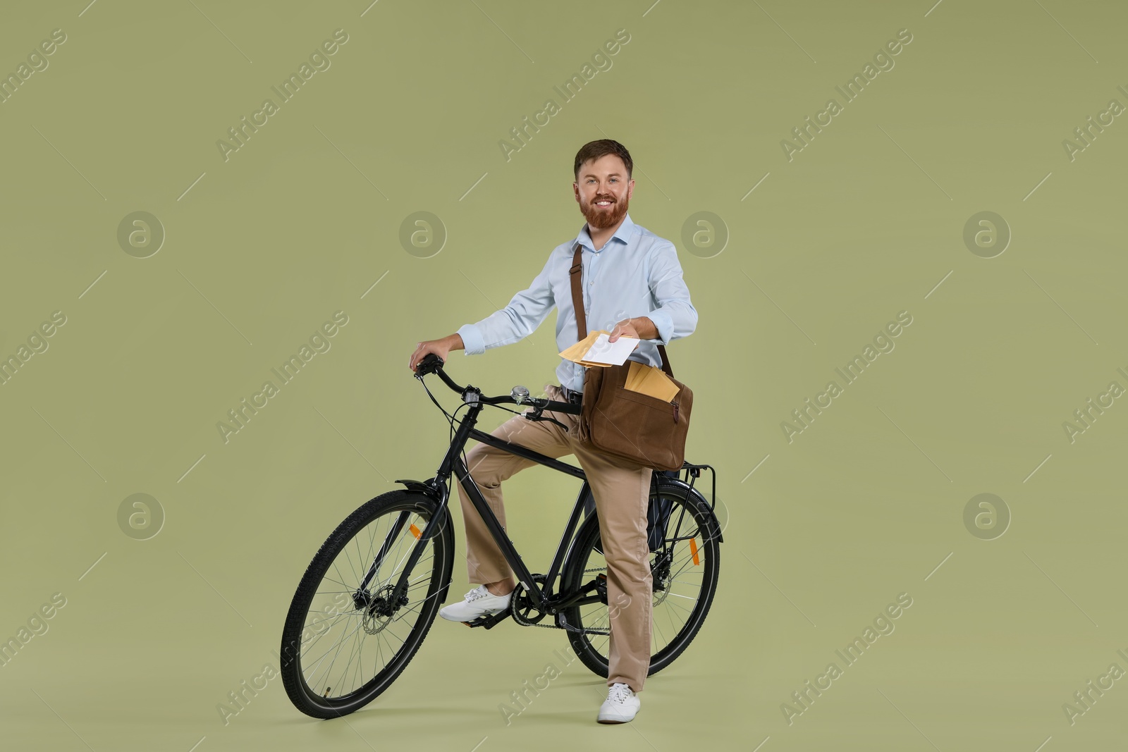 Photo of Postman on bicycle delivering letters against light green background