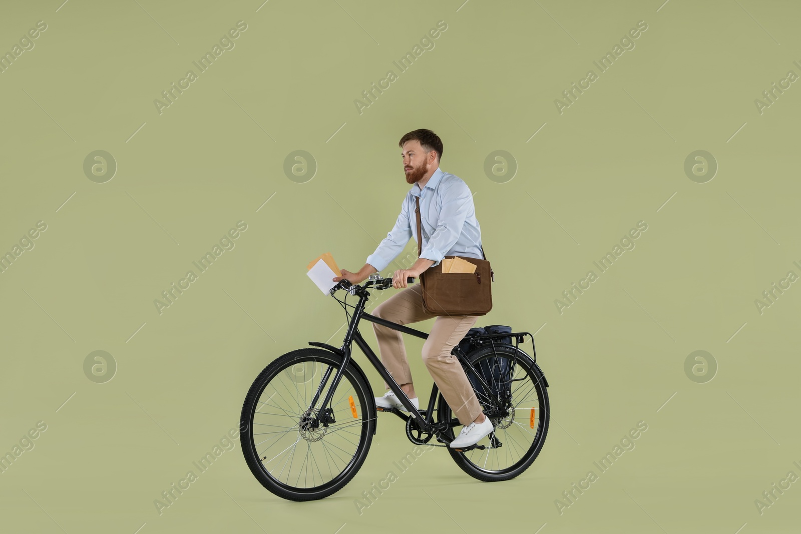 Photo of Postman on bicycle delivering letters against light green background