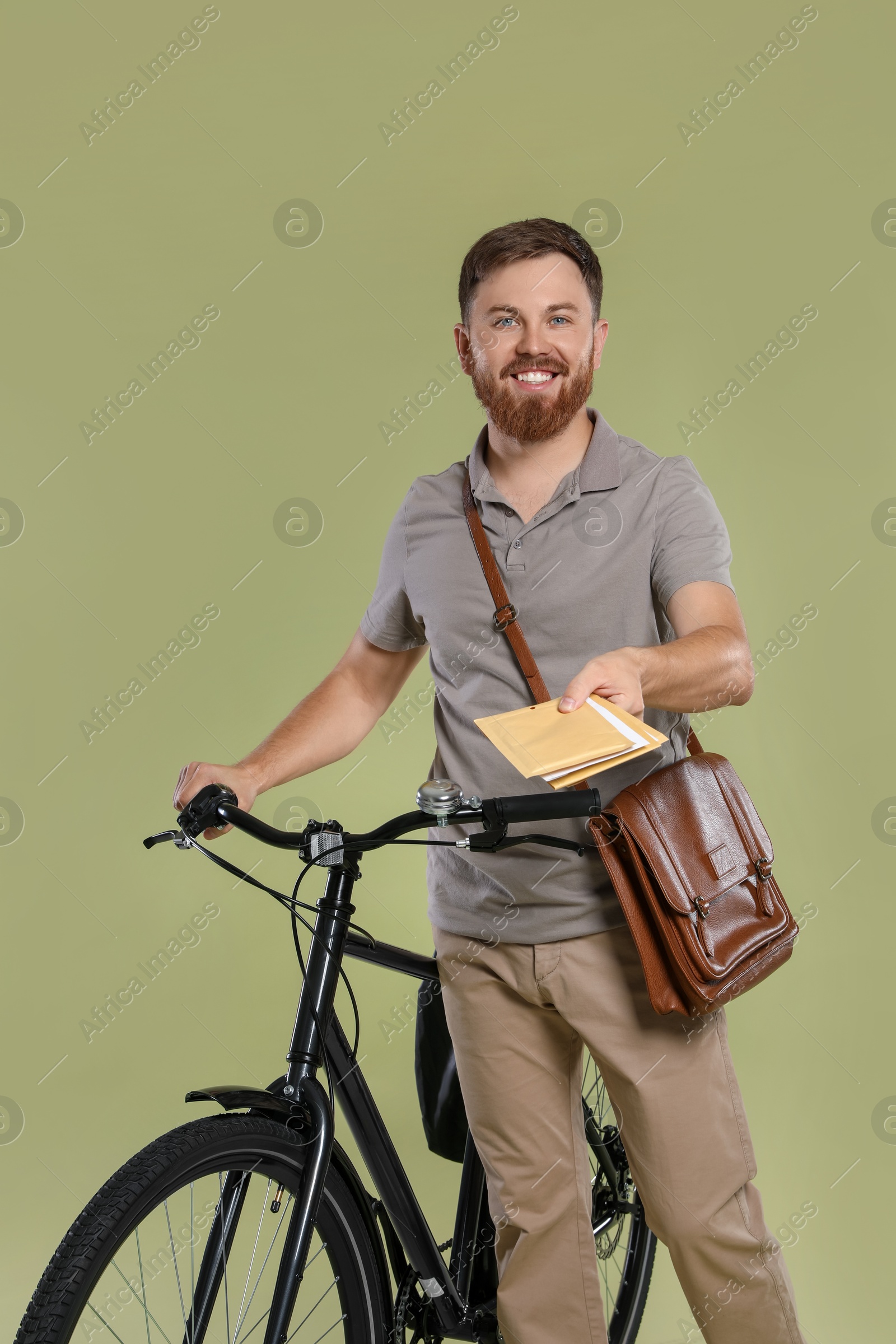 Photo of Postman with bicycle delivering letters on light green background