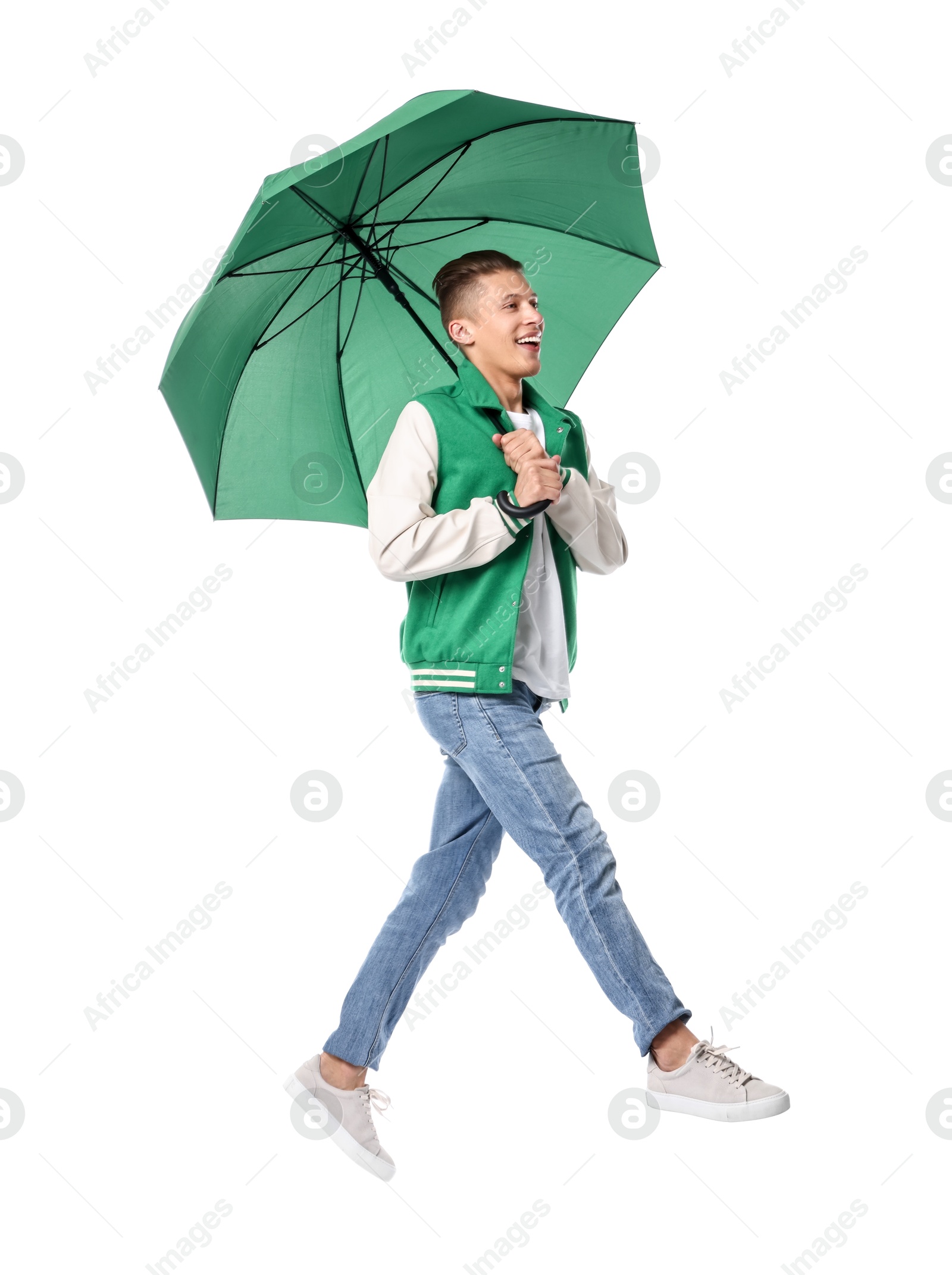 Photo of Young man with green umbrella jumping on white background