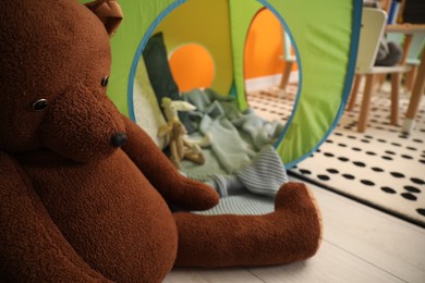 Cute bear toy on floor in child room