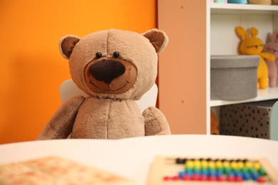 Photo of Teddy bear at white table in child room