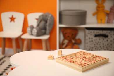 Photo of Wooden cubes on white table in child room