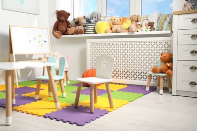 Stylish child room interior with different toys and furniture