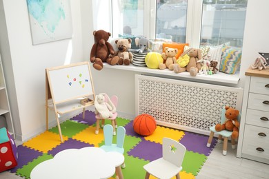 Photo of Stylish child room interior with different toys and furniture