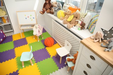 Photo of Stylish child room interior with different toys and furniture