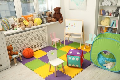 Photo of Stylish child room interior with different toys and furniture