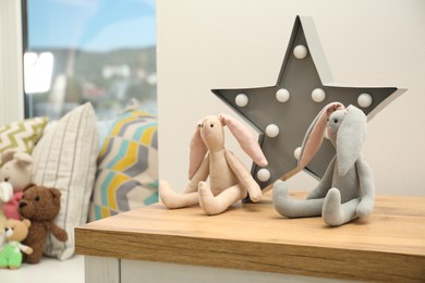 Photo of Bunny toys on wooden surface in child room