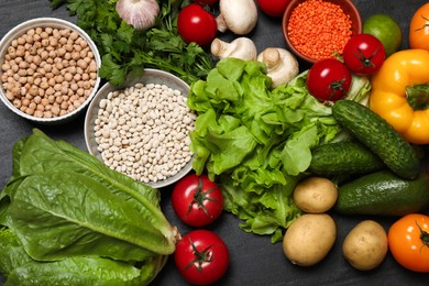 Photo of Healthy vegetarian food. Different vegetables, lentils and mushrooms on dark textured table, flat lay