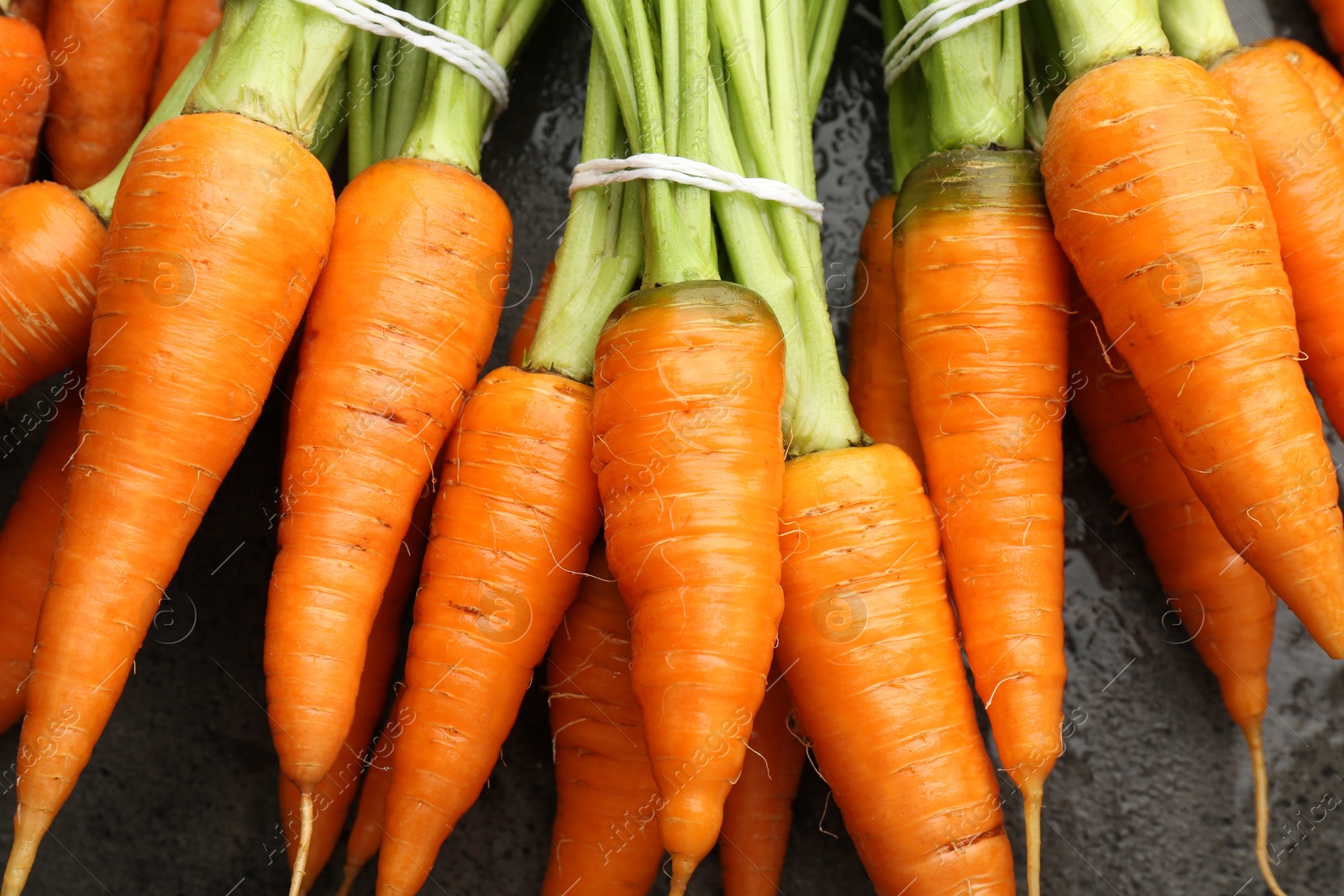 Photo of Tasty ripe juicy carrots on table, top view