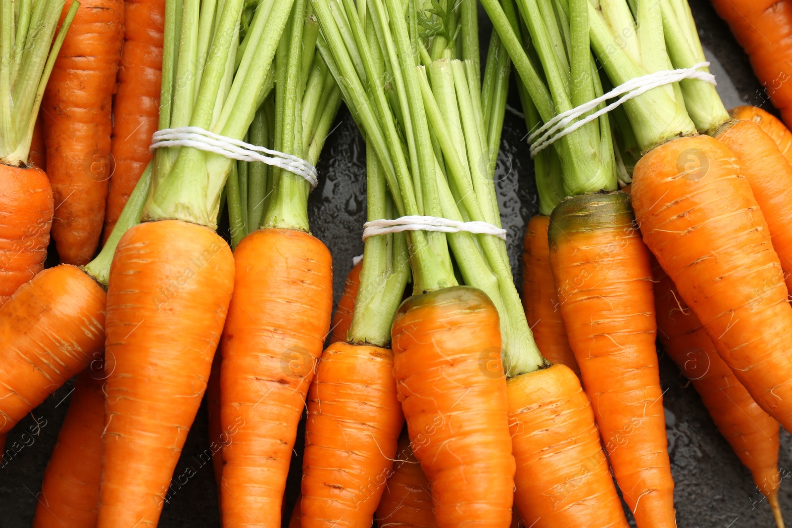 Photo of Tasty ripe juicy carrots on table, top view