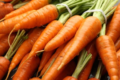 Photo of Tasty ripe juicy carrots on table, closeup