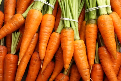 Photo of Tasty ripe juicy carrots as background, top view