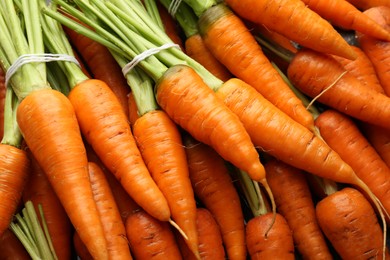 Tasty ripe juicy carrots as background, top view