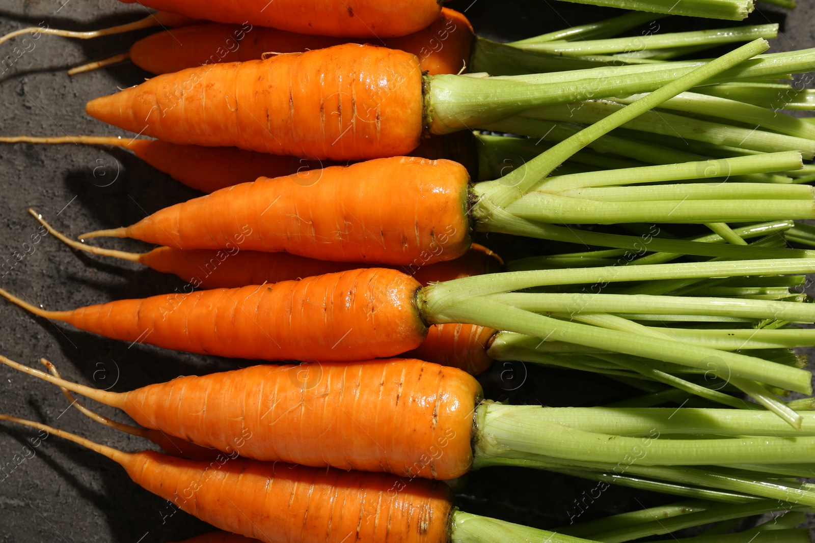 Photo of Tasty ripe juicy carrots on table, top view