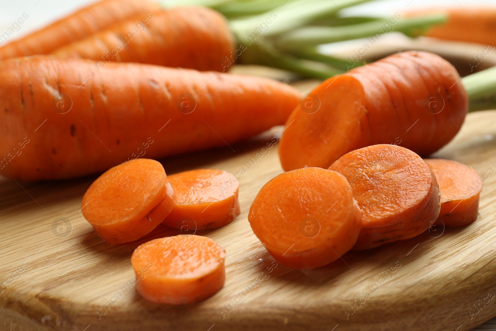 Photo of Whole and cut fresh carrots on table, closeup