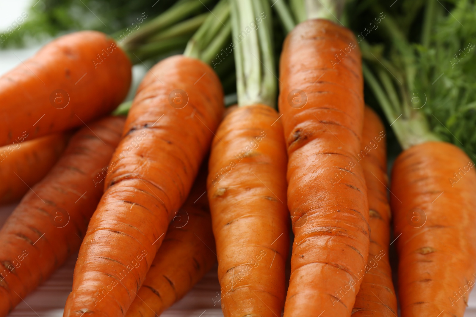 Photo of Tasty ripe juicy carrots on table, closeup