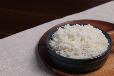 Photo of Delicious boiled rice served on table. Space for text