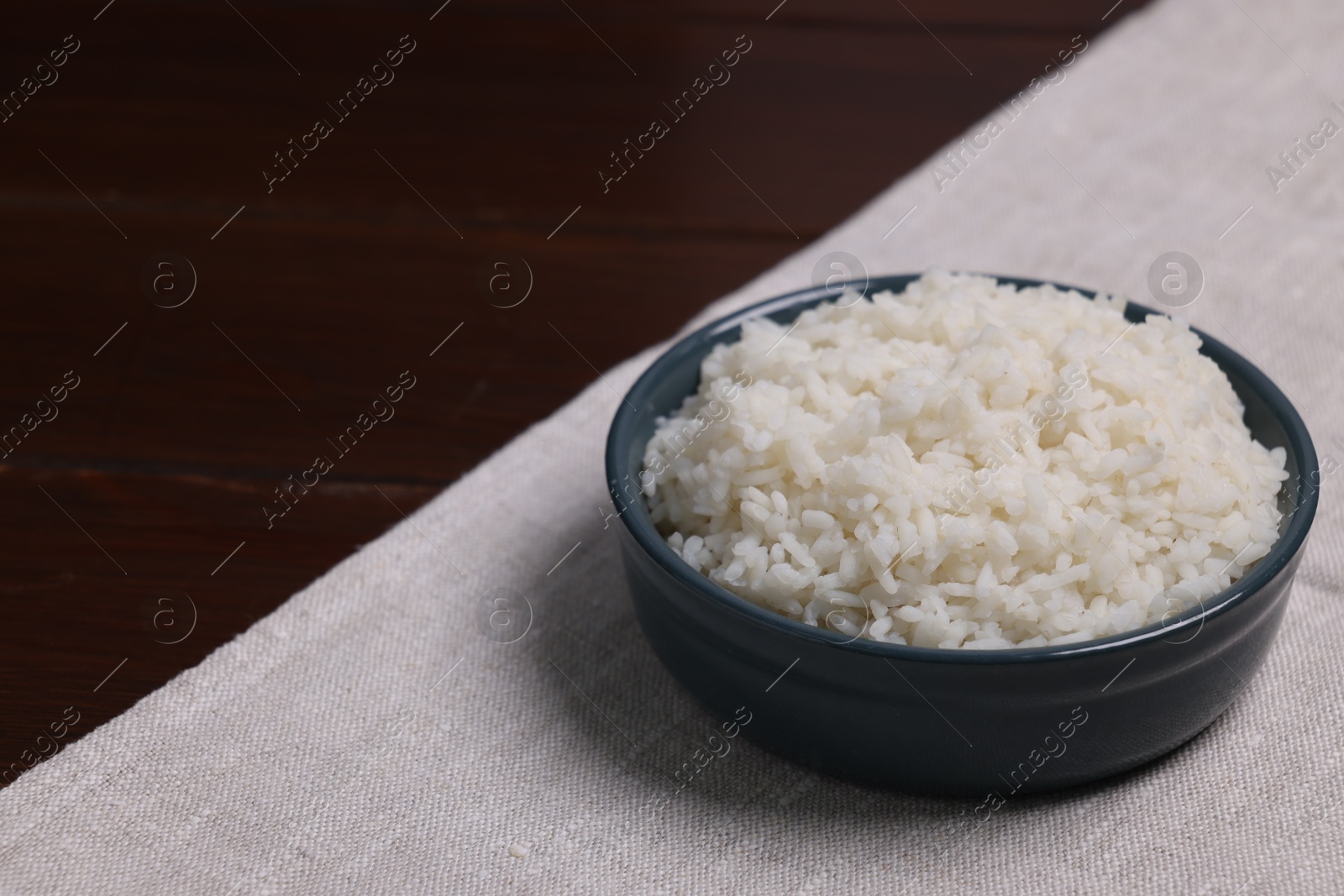 Photo of Delicious boiled rice served on table. Space for text