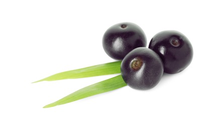 Photo of Fresh ripe acai berries and green leaves isolated on white