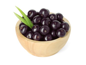 Photo of Fresh ripe acai berries in bowl and green leaves isolated on white