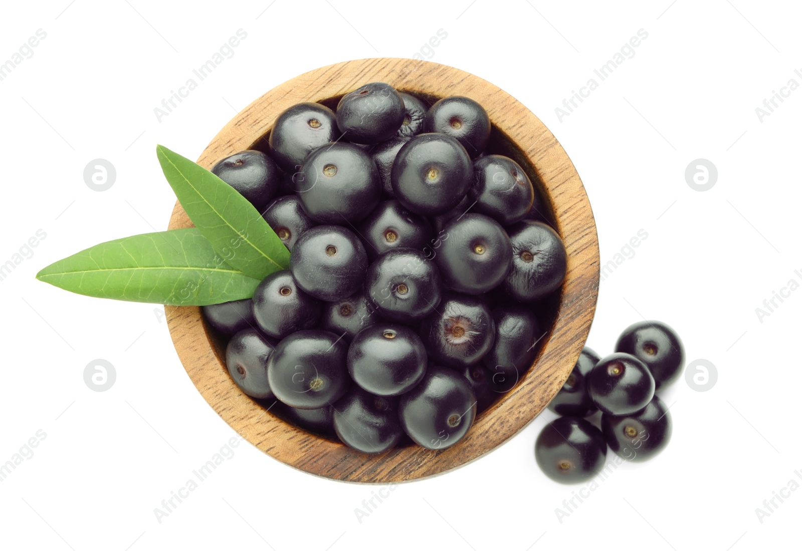 Photo of Fresh ripe acai berries in bowl and green leaves isolated on white, top view