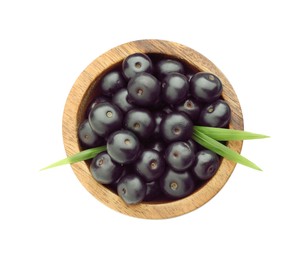 Fresh ripe acai berries in bowl and green leaves isolated on white, top view