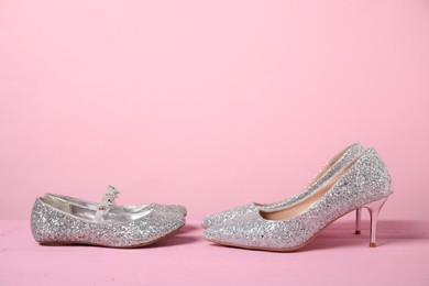 Photo of Big and small shoes on pink background