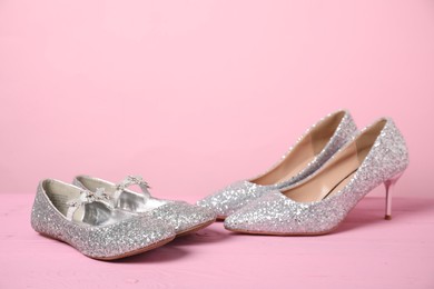 Photo of Big and small shoes on pink background