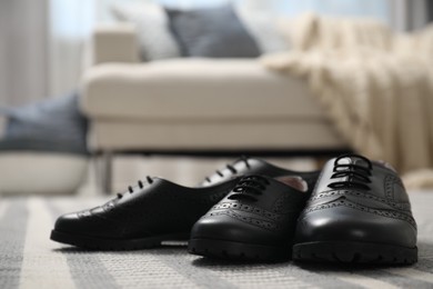 Big and small shoes on carpet indoors