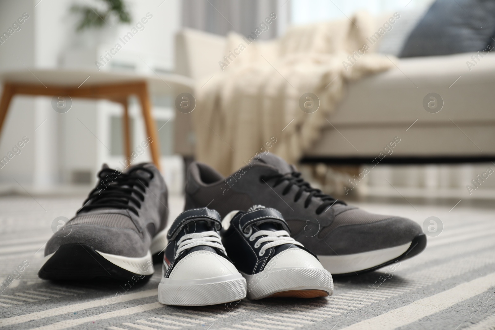 Photo of Big and small sneakers on carpet indoors