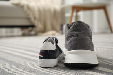 Photo of Big and small sneakers on carpet indoors