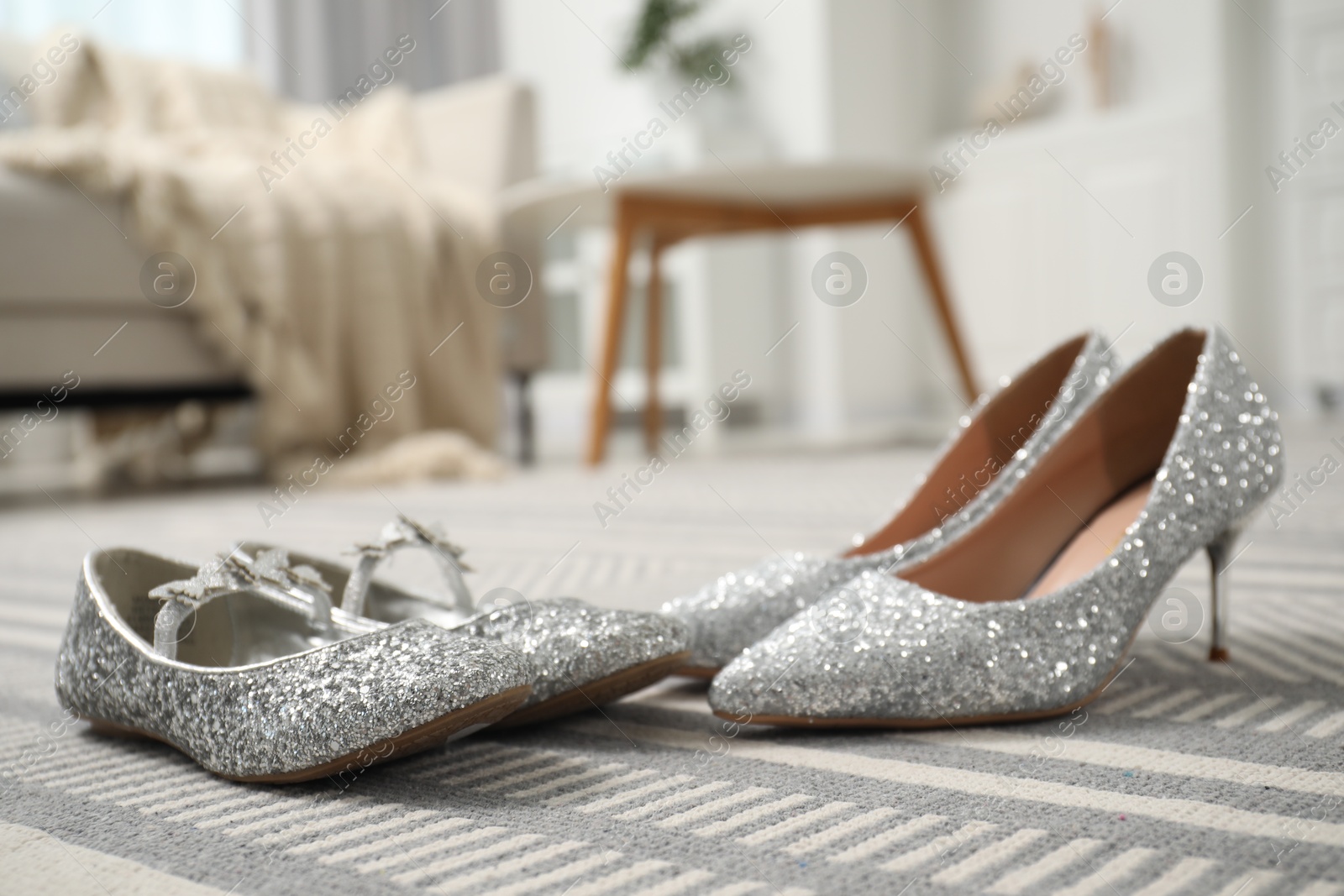 Photo of Big and small shoes on carpet indoors