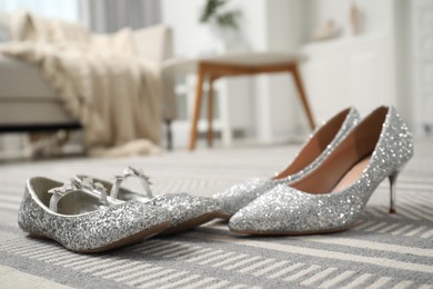 Big and small shoes on carpet indoors