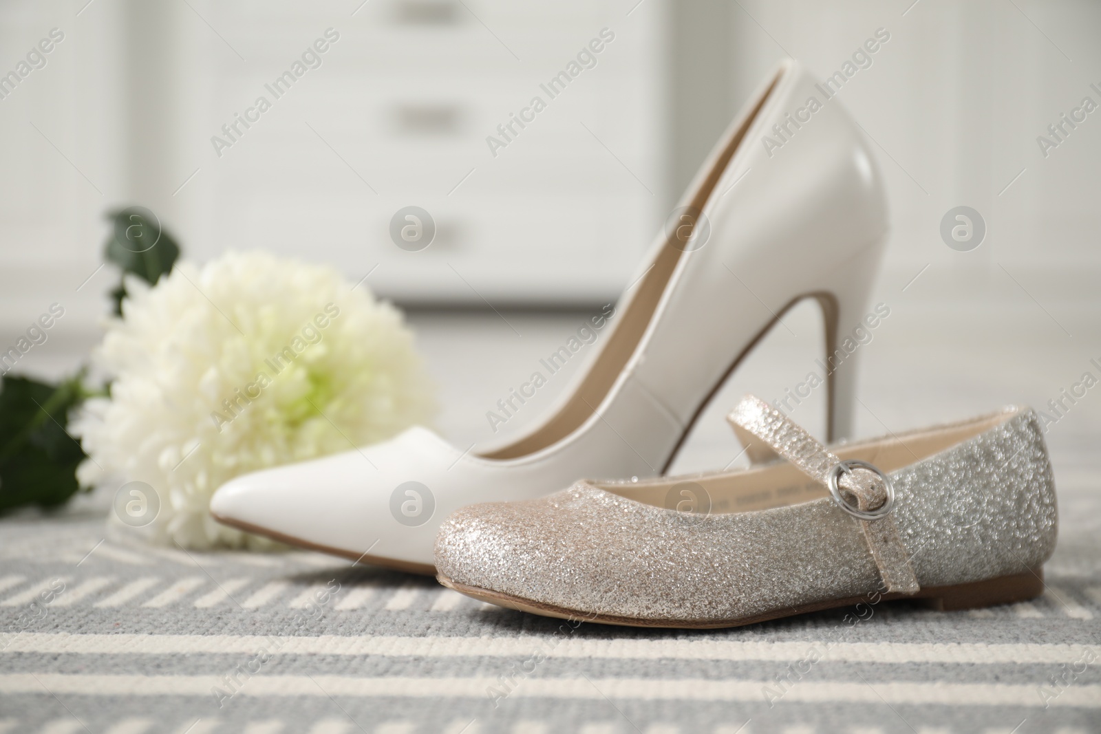 Photo of Big and small shoes on carpet indoors, closeup