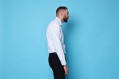 Photo of Man with poor posture on light blue background